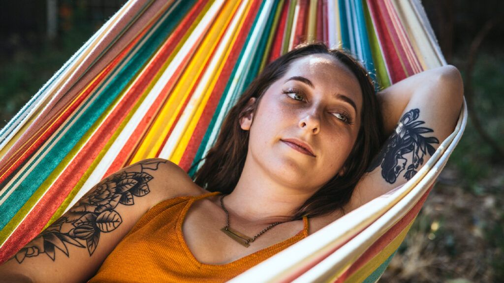 a woman is lying on a hammock