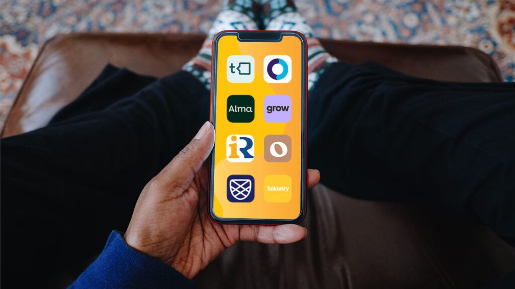 person holding smart phone in hand. background is orange, and there are apps of 8 therapy services that take insurance